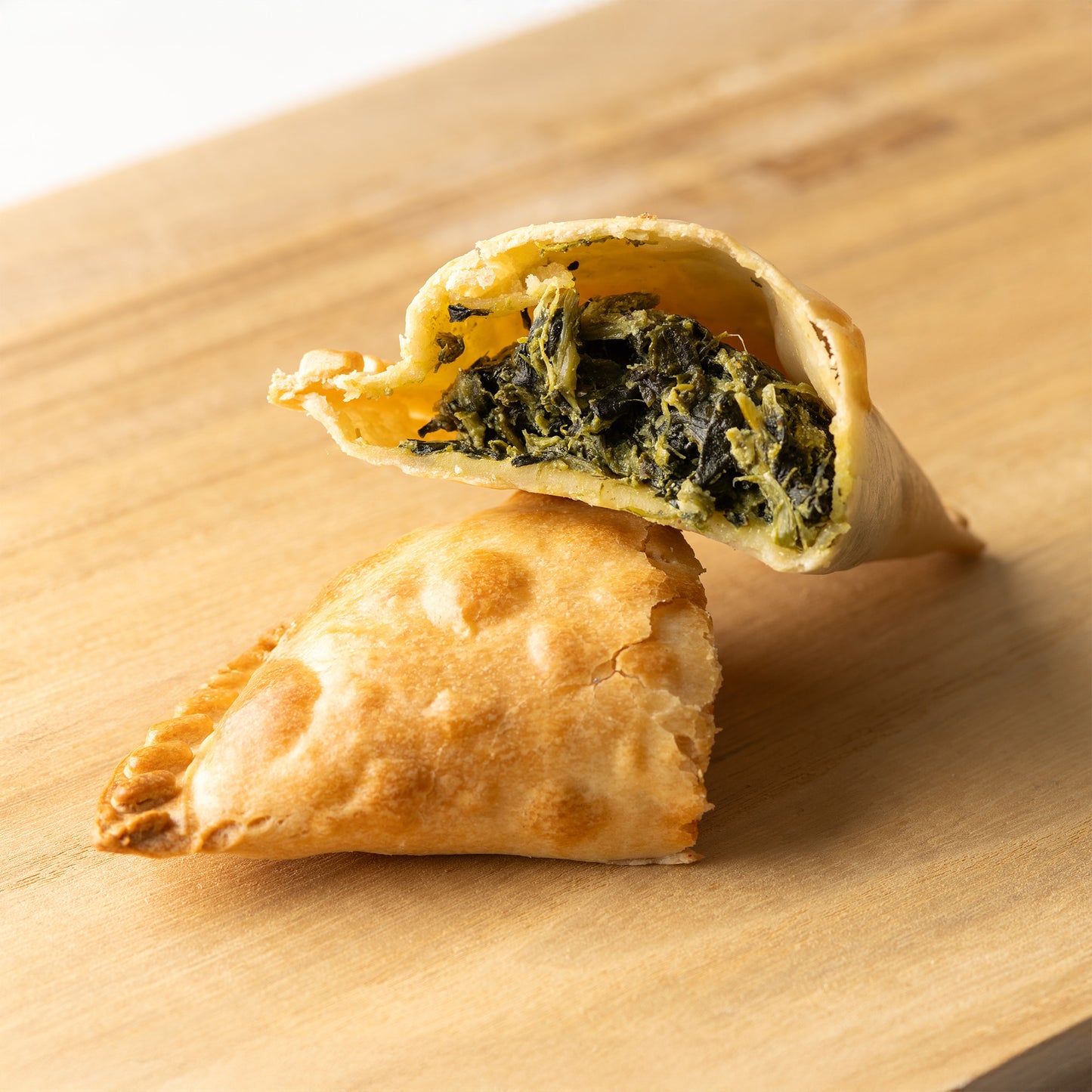 Empanada argentina rellena de espinaca — masa crujiente con un sabroso relleno de espinaca fresca y especias, perfecta para fiestas, reuniones o meriendas, disponible en RockaPan con envío a todo EE. UU.