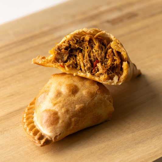 Empanada argentina rellena de carne mechada — masa crujiente con jugosa carne deshebrada y sazonada al estilo tradicional, ideal para fiestas y reuniones, disponible en RockaPan con envío a todo EE. UU.”
