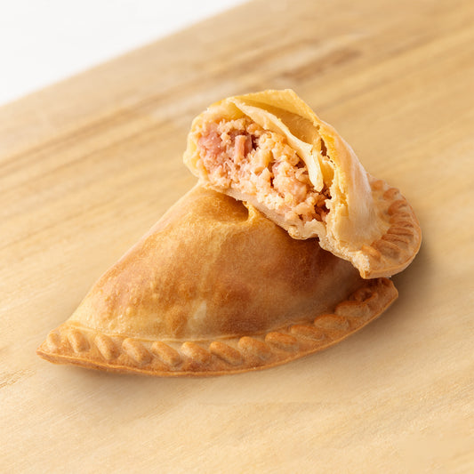 Empanada argentina rellena de jamón y queso — masa crujiente con delicioso jamón y queso derretido, ideal para fiestas, reuniones o meriendas, disponible en RockaPan con envío a todo EE. UU.
