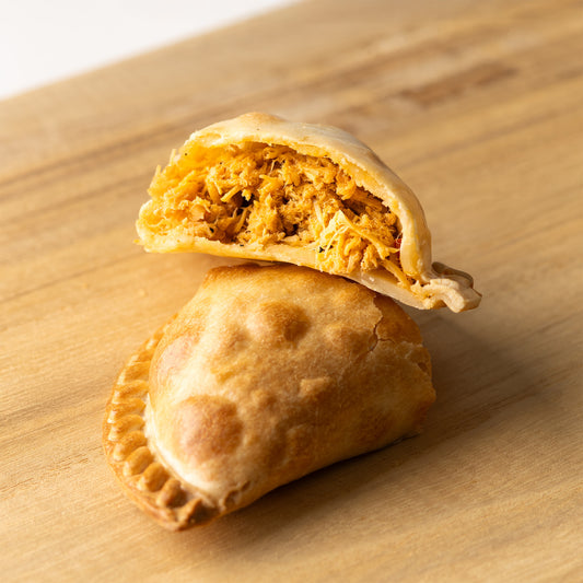 Empanada argentina rellena de pollo desmenuzado y especias, con masa dorada al horno


